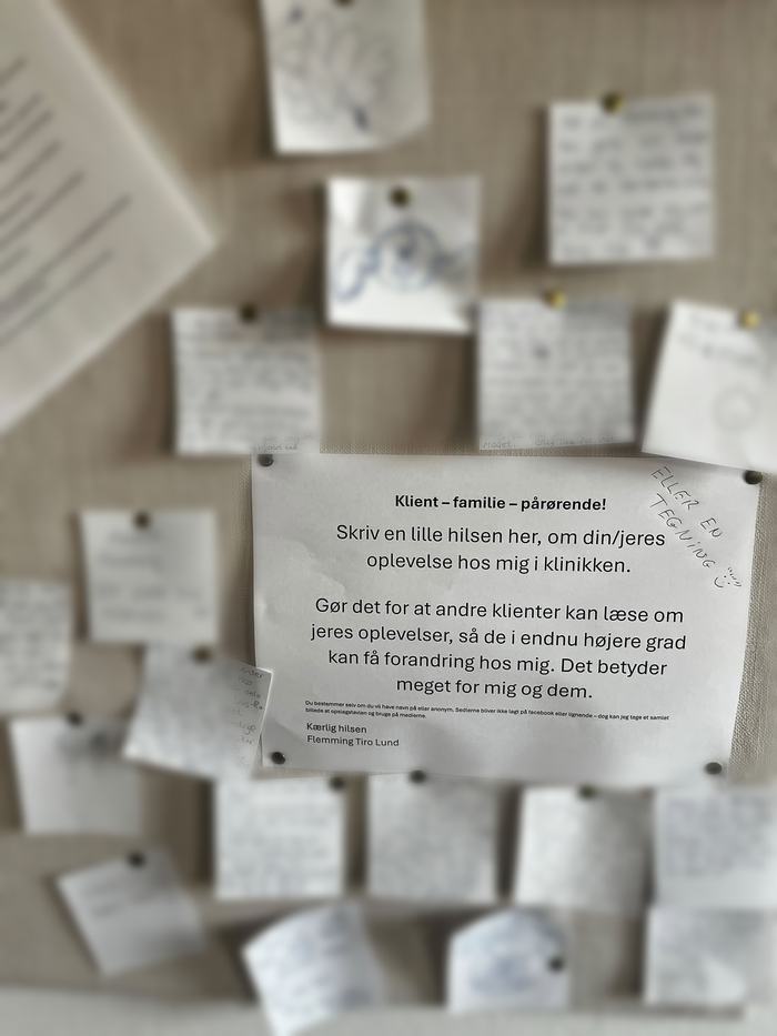 Opslagstavlen i klinikken med håndskrevne hilsner og tegninger fra klienter